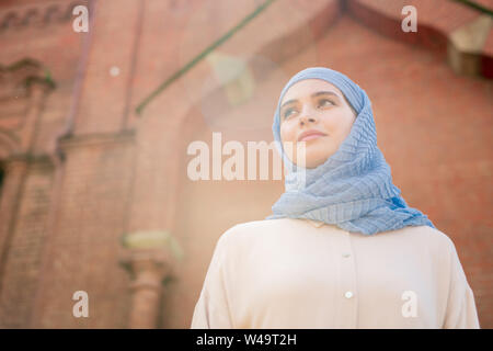 Giovani femmine in hijab guardando in avanti tenendo a piedi giù città antica Foto Stock