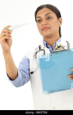 Medico donna controllo temperatura termometro digitale Foto Stock