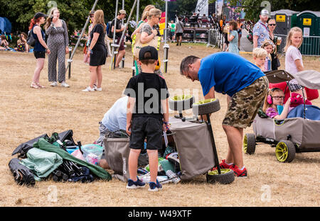 Famiglia con un carrello ribaltata a Latitude Festival, Henham Park, Suffolk, Regno Unito, 21 Luglio 2019 Foto Stock