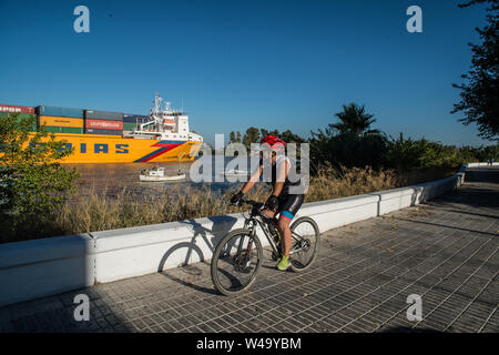 Il passaggio di una nave cargo partì dal porto di Siviglia e navigare il fiume Guadalquivir all'oceano. Coria del Rio, Andalucia, Luglio 2019 Foto Stock