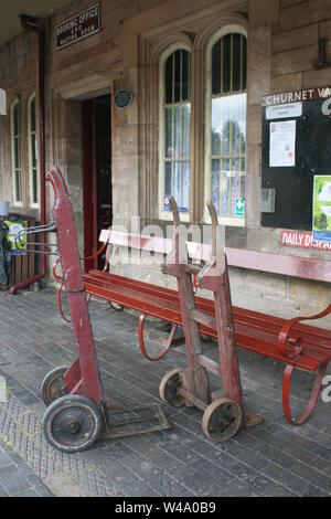 Coppia di sacco vintage carrelli o ferroviarie Carrelli bagagli sulla piattaforma a Cheddleton conserve di stazione ferroviaria Foto Stock