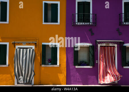 Due case vivacemente colorate su fondamenta Cao di Rio e a sinistra sul Rio Terranova, Burano, Laguna Veneziana, Veneto, Italia Foto Stock