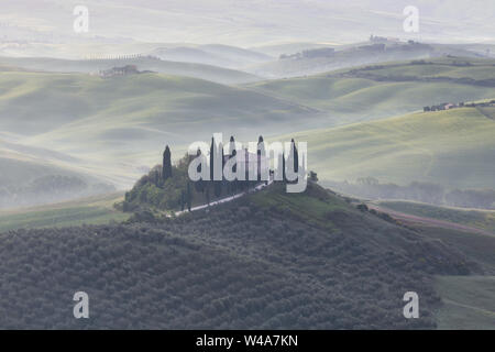 Famosa villa Podere in Val d'Orcia durante foggy sunrise in Toscana. Pienza, Italia. Foto Stock