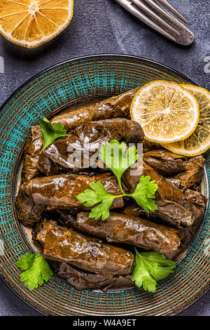 Dolma, ripieni di foglie di uva con riso e carne su sfondo scuro, vista dall'alto. Foto Stock