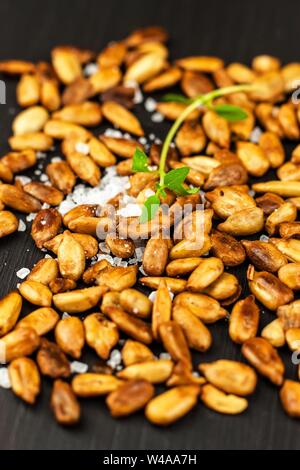 Tostati e salati di semi di girasole. Semi di girasole nella ciotola su sfondo di legno. Cibo vegan. Foto Stock