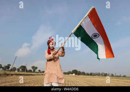 Agricoltore che sventolava una bandiera indiana in un campo Foto Stock