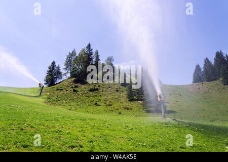 Per la produzione di neve macchine utilizzate per acqua erba sul pendio, soleggiata giornata estiva, Wagrain ski resort, Austria Foto Stock