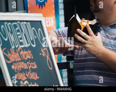 Carrelli di cibo si riuniscono per un festival in Sanford, Florida. Uomo con scatola di cibo. Foto Stock