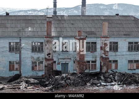 Vecchio distrutto abbandonato casa di mattoni con le rotture di windows e la distrusse i camini di mattoni Foto Stock