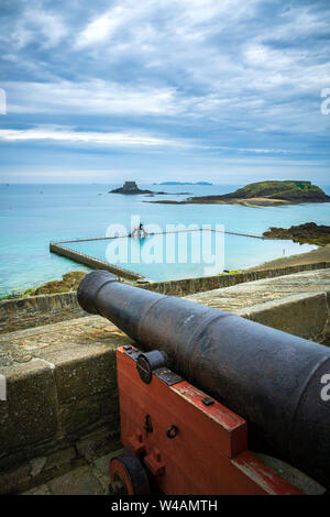 Antico borgo medievale cannone di difesa sui bastioni di St Malo con Grand Bé island e la baia di sfondo, Brittany, Francia. Foto Stock