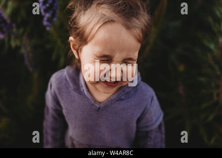 Close up ritratto di poco il toddler girl scrunching naso e ridere Foto Stock