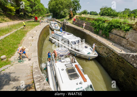 Una serratura sul Canal du Midi Francia su un giorno d'estate con tre barche a motore in esso Foto Stock