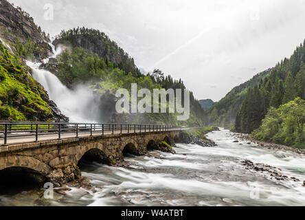 Latefoss cascate ruscelli sotto il ponte di pietra agli archi, Odda, Hordaland county, Norvegia Foto Stock