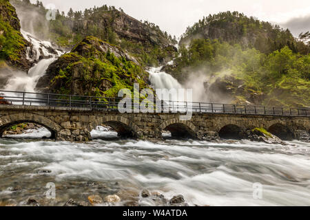 Twin Latefoss cascate ruscelli sotto il ponte di pietra agli archi, Odda, Hordaland county, Norvegia Foto Stock