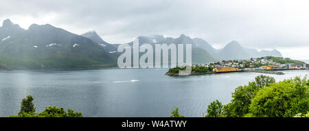 Husoy island village panorama con le montagne sullo sfondo, Senja isola, Troms County, Norvegia Foto Stock