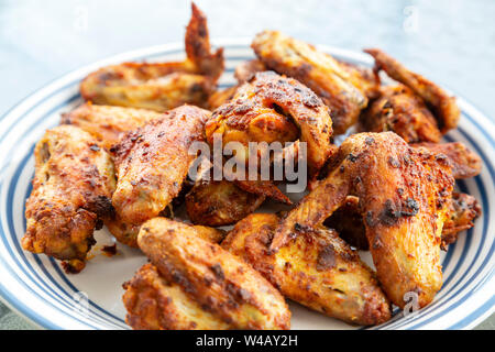 Grigliata di ali di pollo con un secco rub marinata di curry in polvere e la curcuma. Foto Stock