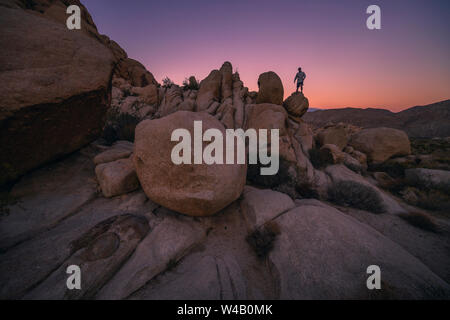 La scalata di massi al tramonto vicino a Joshua Tree Foto Stock