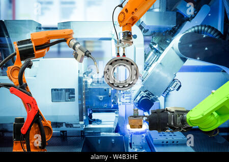 Industriali di saldatura robotizzata e il robot di presa sul lavoro smart factory, sulla macchina le tonalità blu colore di sfondo, industria 4.0 e tecnologia. Foto Stock