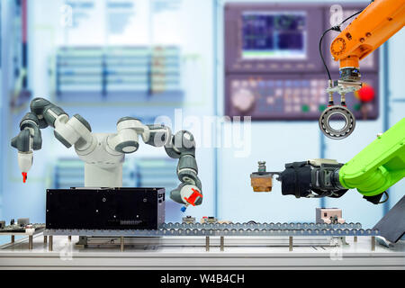 La robotica industriale lavora attraverso il nastro trasportatore su smart factory, terminale e pannello di controllo tono blu il colore su sfondo sfocato, industria 4.0 concetto Foto Stock