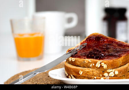 Fette di pane con pane tostato con fatti in casa confettura di fragole per la colazione Foto Stock