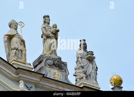 Madonna con il bambino e i due altre statue, un vescovo e un altro santo femminile, sulla parte superiore di un edificio in un angolo della Città Vecchia Market Place (Miasto S Foto Stock