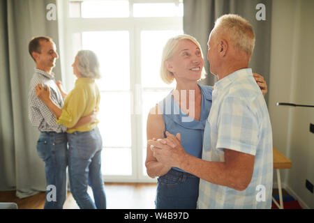 Ritratto di due coppie senior dancing romanticamente durante la festa a casa, spazio di copia Foto Stock
