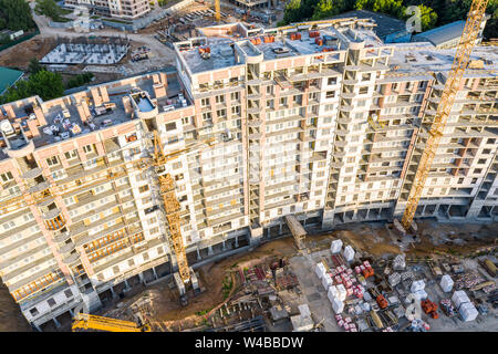 La costruzione del nuovo appartamento multistory building. gialla gru a torre in cantiere. vista aerea Foto Stock