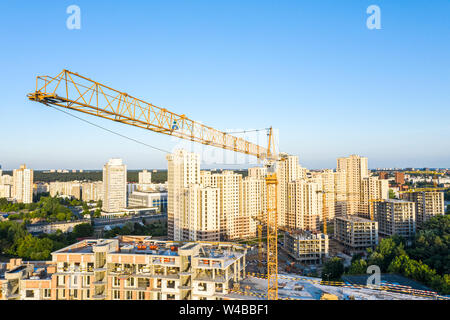 Antenna vista panoramica di nuova costruzione appartamento edificio. giallo gru a torre contro il cielo blu sullo sfondo Foto Stock