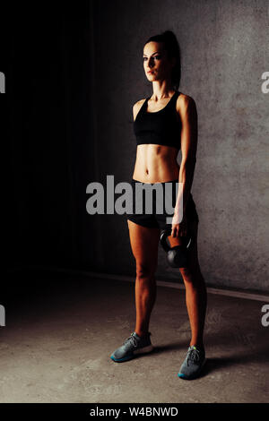 Giovane donna holding kettlebell Foto Stock