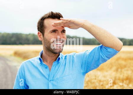 Ritratto di un giovane uomo che guarda avanti felicemente Foto Stock