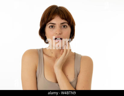 Giovane e bella bruna red ingaggiato donna con la faccia felice di puntamento e compiendo gesti sorpreso e guardando qualcosa di scioccante e buona. Faci umana Foto Stock