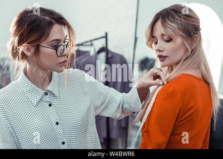 I capelli rossi shopping assistant misura facendo per client Foto Stock