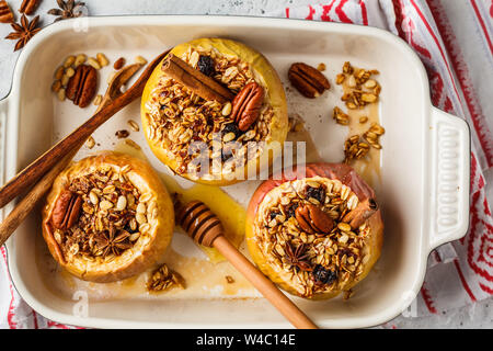 Mele cotte con muesli, mirtilli, noci e miele nella teglia da forno. Foto Stock