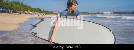 Surfer con la sua tavola da surf in esecuzione alle onde banner, formato lungo Foto Stock