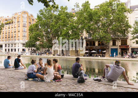 Parigi Canal Saint Martin - persone sedute lungo il Canal Saint Martin, nel decimo arrondissement di Parigi, in Francia, in Europa. Foto Stock