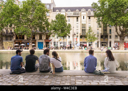 Parigi Canal Saint Martin - persone sedute lungo il Canal Saint Martin, nel decimo arrondissement di Parigi, in Francia, in Europa. Foto Stock