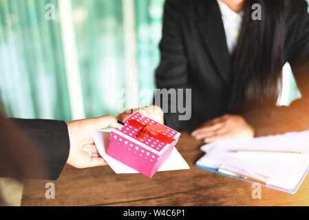 Asian business donna stipendio ricevere bonus in denaro e confezione regalo da boss o manager di ufficio felicemente / annuale il concetto di Bonus per l'incoraggiamento morale Foto Stock