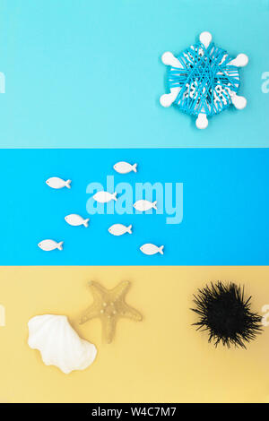 Spiaggia di astratta composizione dalla carta colorata, legno pesci bianchi, bianco seashell, stella di mare, nero dei ricci di mare e white ship helms come il sole con c Foto Stock
