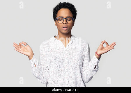 Calma biracial donna pratica yoga il controllo di emozioni Foto Stock