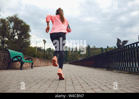 Bambina corre lungo la strada nel parco. Foto Stock