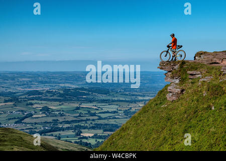 Un uomo che si impacchettano nei Brecon Beacons in Galles durante l'estate. Mountain bike Brecon Beacons. Foto Stock