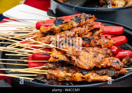 Salsicce di filippini e barbecue su bastoni o spiedini di legno. Foto Stock