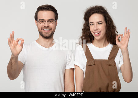 Coppia giovane mostra ok segno dando parere positivo studio shot Foto Stock