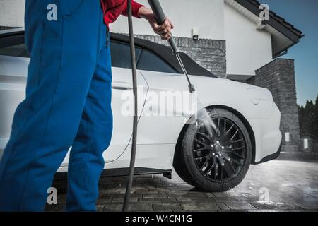Auto moderna pulizia utilizzando la rondella a pressione. Concetto automobilistico. Contemporanea viale residenziale ubicazione. Foto Stock