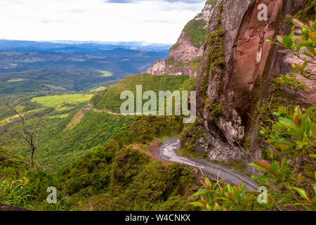 Lunga discesa lungo la strada sinuosa della bellissima Serra do Corvo Branco, con pareti in pietra e un sacco di vegetazione, Uruubici, Santa Catatarina Foto Stock