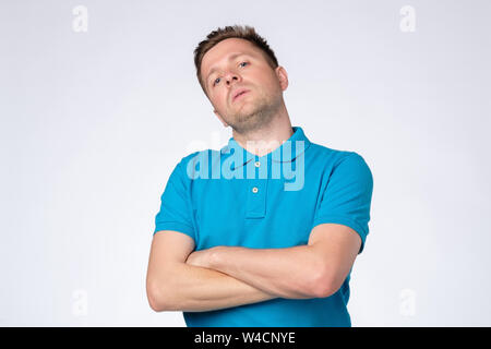 Uomo in posa di studio con le braccia incrociate e fissando la telecamera con arrogante presuntuoso cercare Foto Stock