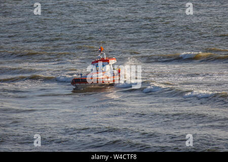 Egmond aan Zee, Paesi Bassi - 22 Luglio 2019: membri della guardia costiera olandese su una scialuppa di salvataggio in mare del nord durante un trapano di salvataggio Foto Stock