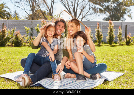 Famiglia con bambini è in possesso di ombrello su assicurazione e home concetto di costruzione Foto Stock