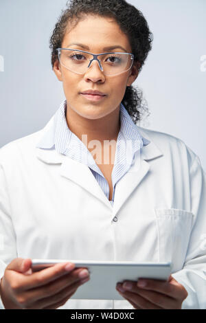 Studio ritratto femminile di tecnico di laboratorio lavora con tavoletta digitale Foto Stock