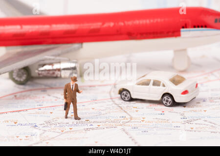 Statuine in miniatura del viaggiatore con mappa ,aereo,auto,sfondo concetto aziendale Foto Stock